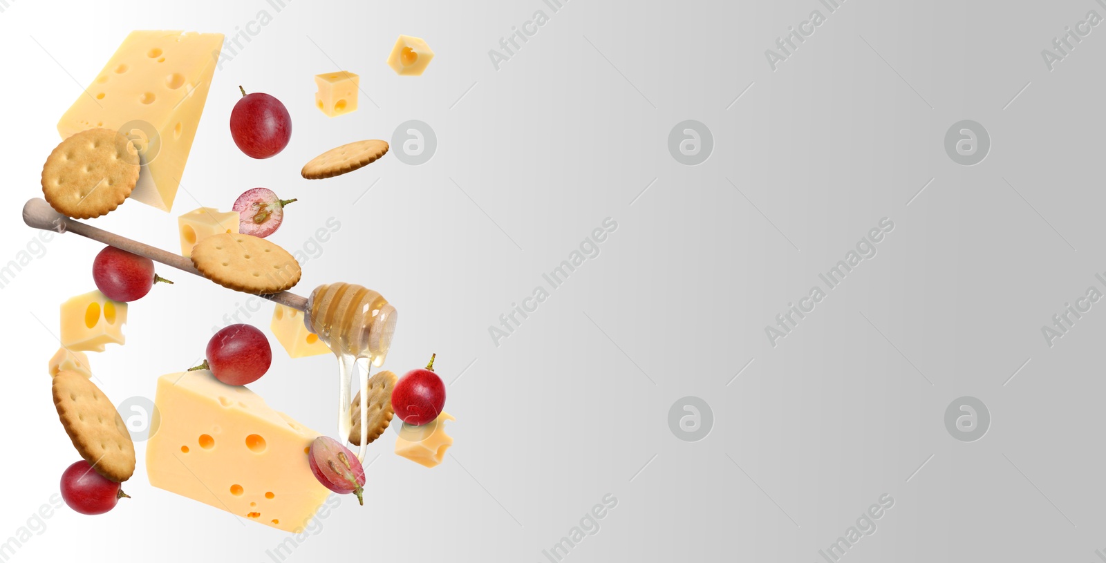 Cheese, grapes, crackers and honey in air on grey gradient background. Tasty appetizers for cheese board Image of Cheese, grapes, crackers and honey in air on grey gradient background. Tasty appetizers for cheese board