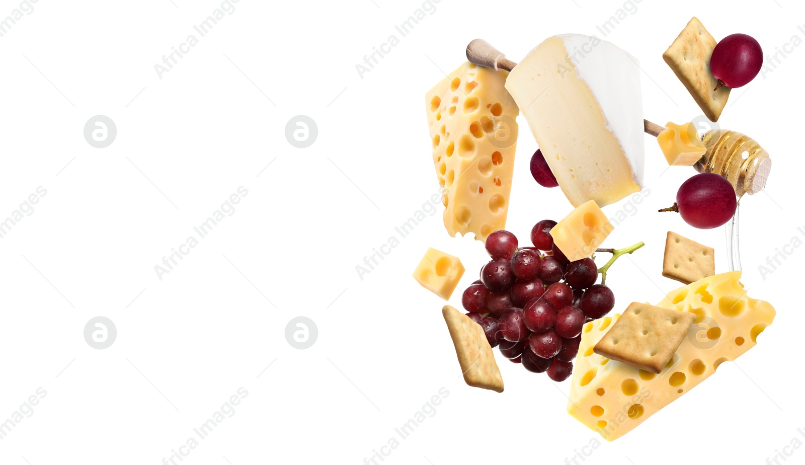 Image of Cheese board products in air on white background. Different types of cheese, grapes, crackers and honey