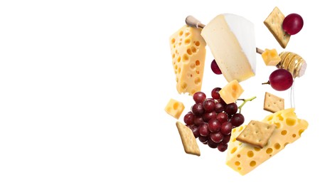 Image of Cheese board products in air on white background. Different types of cheese, grapes, crackers and honey