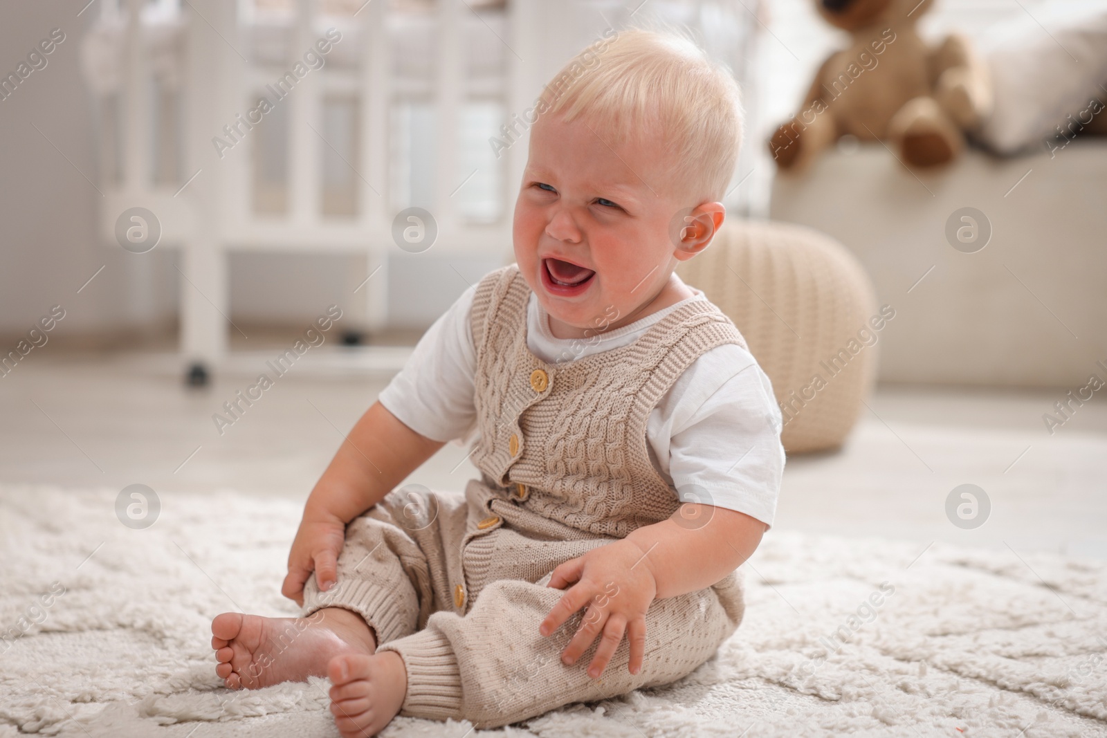 Photo of Newborn baby crying on carpet at home