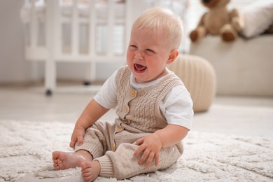 Photo of Newborn baby crying on carpet at home