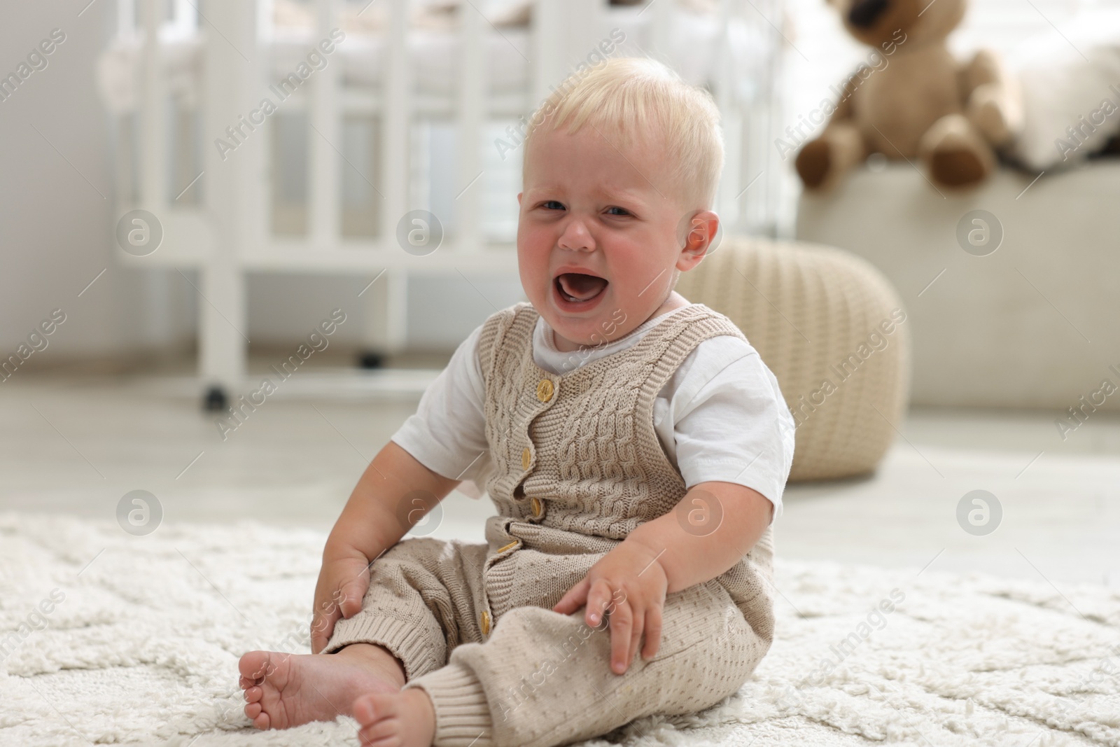 Photo of Newborn baby crying on carpet at home