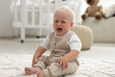 Photo of Newborn baby crying on carpet at home
