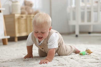 Photo of Newborn baby crying on carpet at home