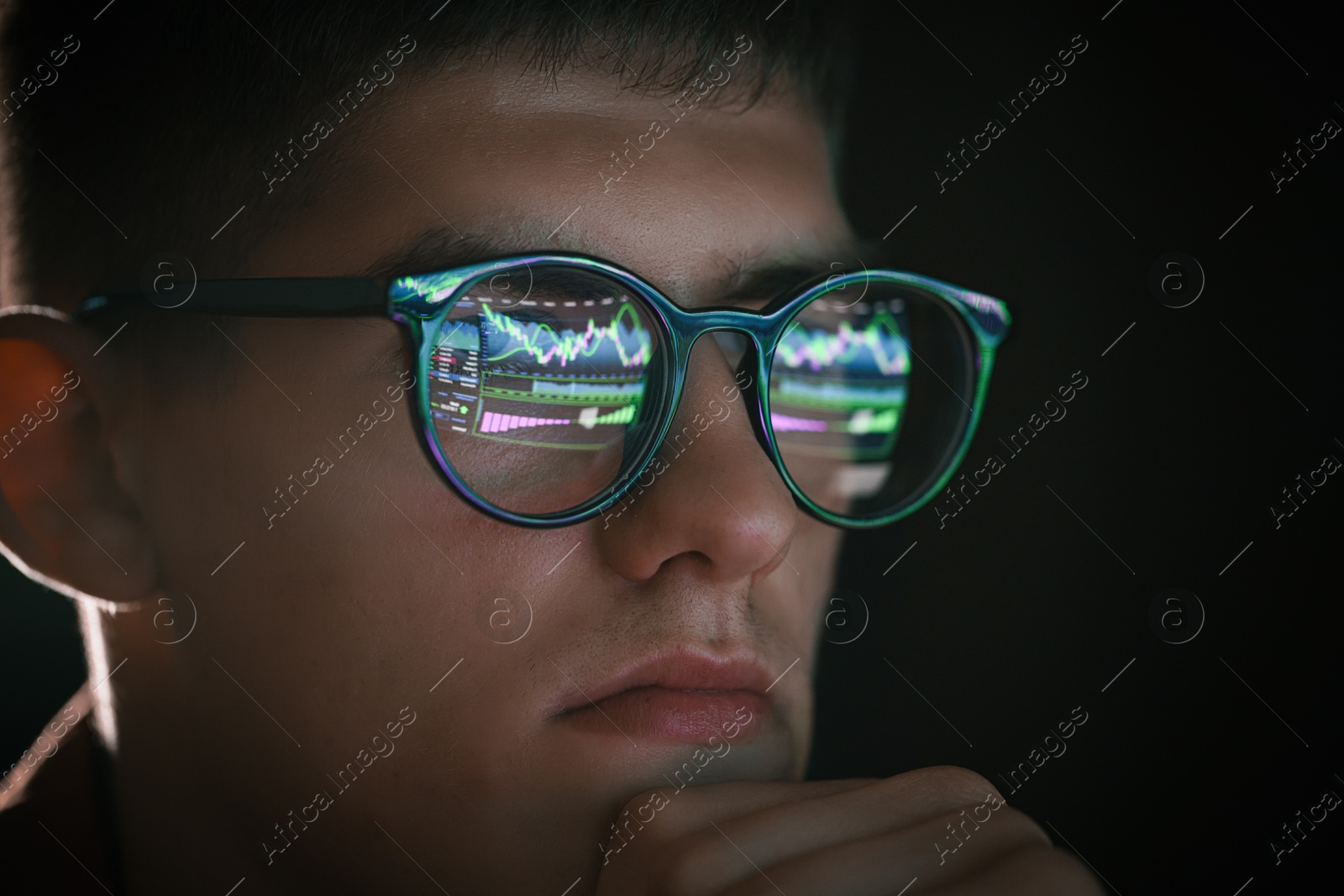 Young man wearing glasses with reflection on black background, closeup Photo of Young man wearing glasses with reflection on black background, closeup