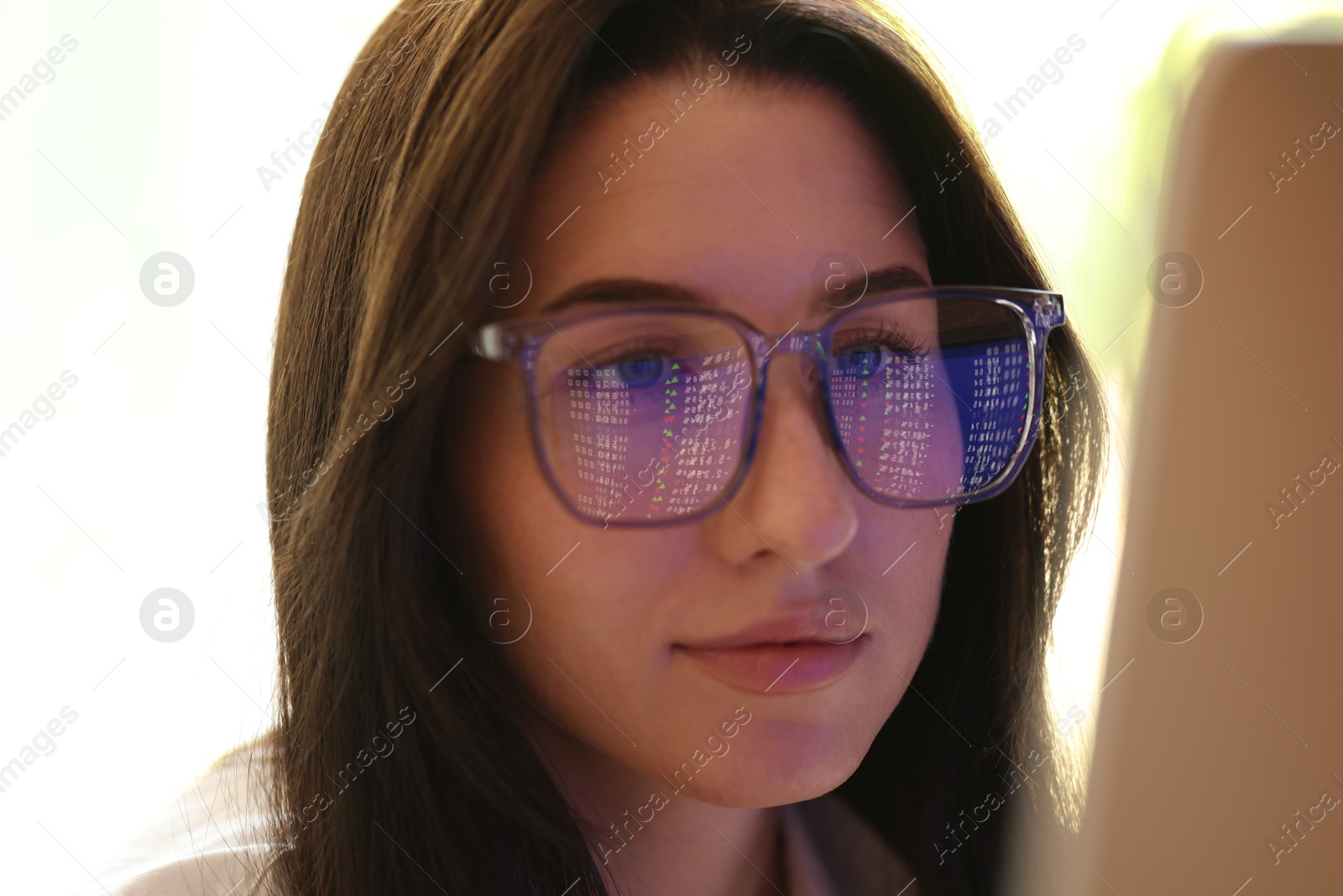 Young woman wearing glasses with reflection indoors, closeup Photo of Young woman wearing glasses with reflection indoors, closeup