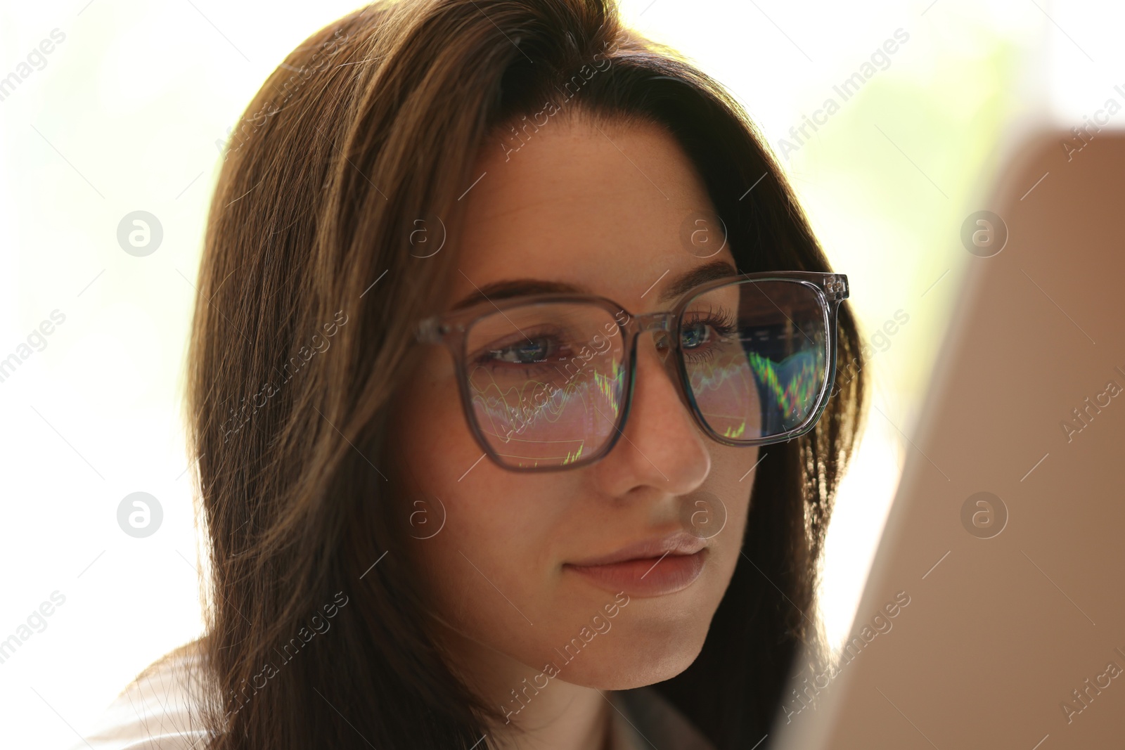 Young woman wearing glasses with reflection indoors, closeup Photo of Young woman wearing glasses with reflection indoors, closeup