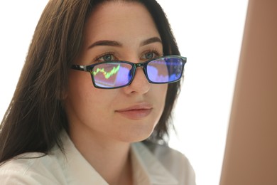 Photo of Young woman wearing glasses with reflection indoors, closeup