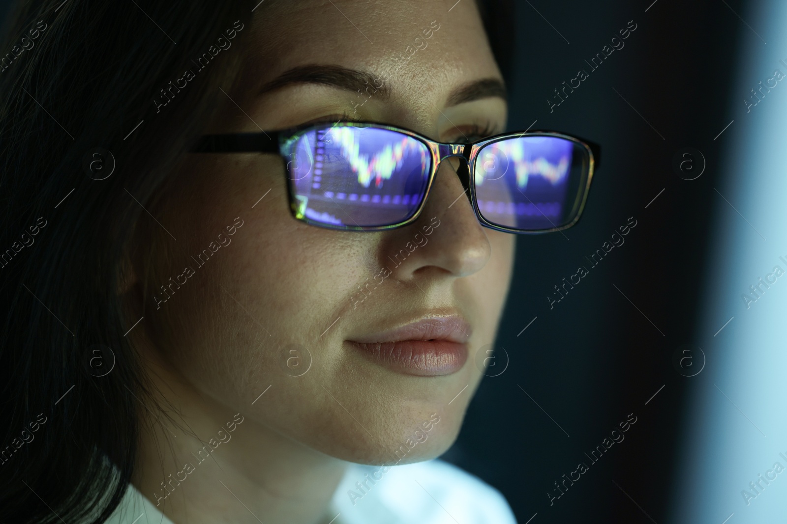 Young woman wearing glasses with reflection on dark background, closeup Photo of Young woman wearing glasses with reflection on dark background, closeup
