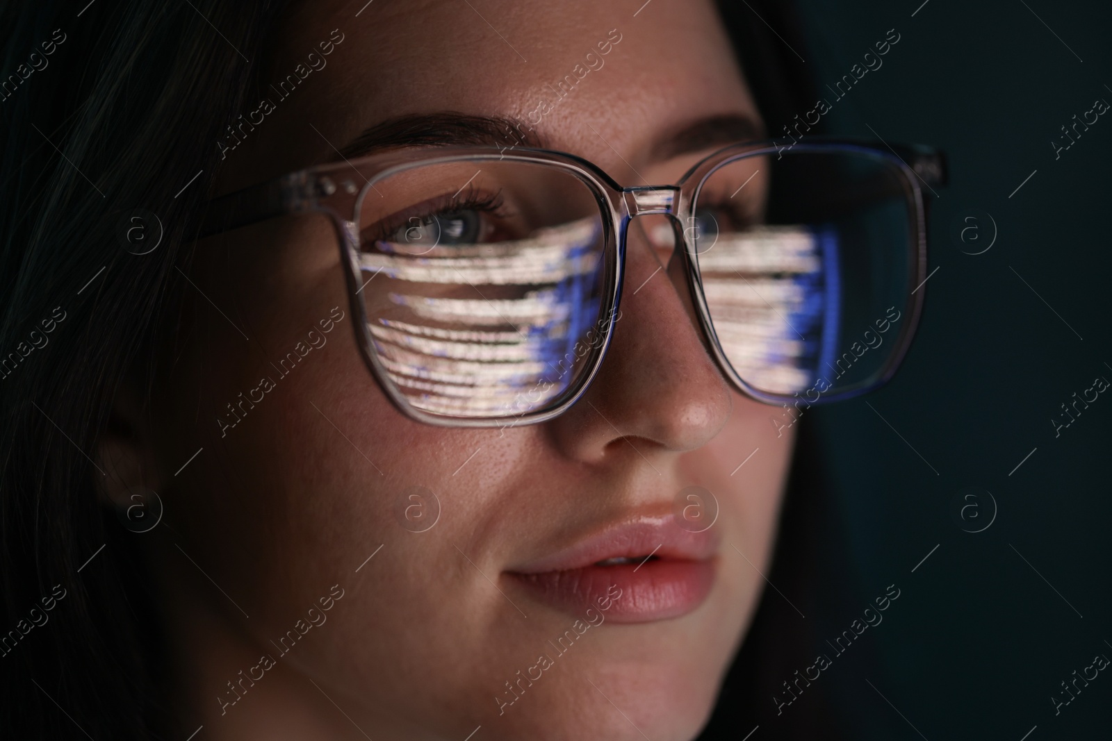 Young woman wearing glasses with reflection on dark background, closeup Photo of Young woman wearing glasses with reflection on dark background, closeup