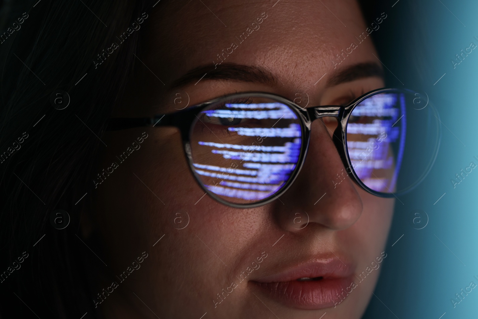 Young woman wearing glasses with reflection on dark background, closeup Photo of Young woman wearing glasses with reflection on dark background, closeup