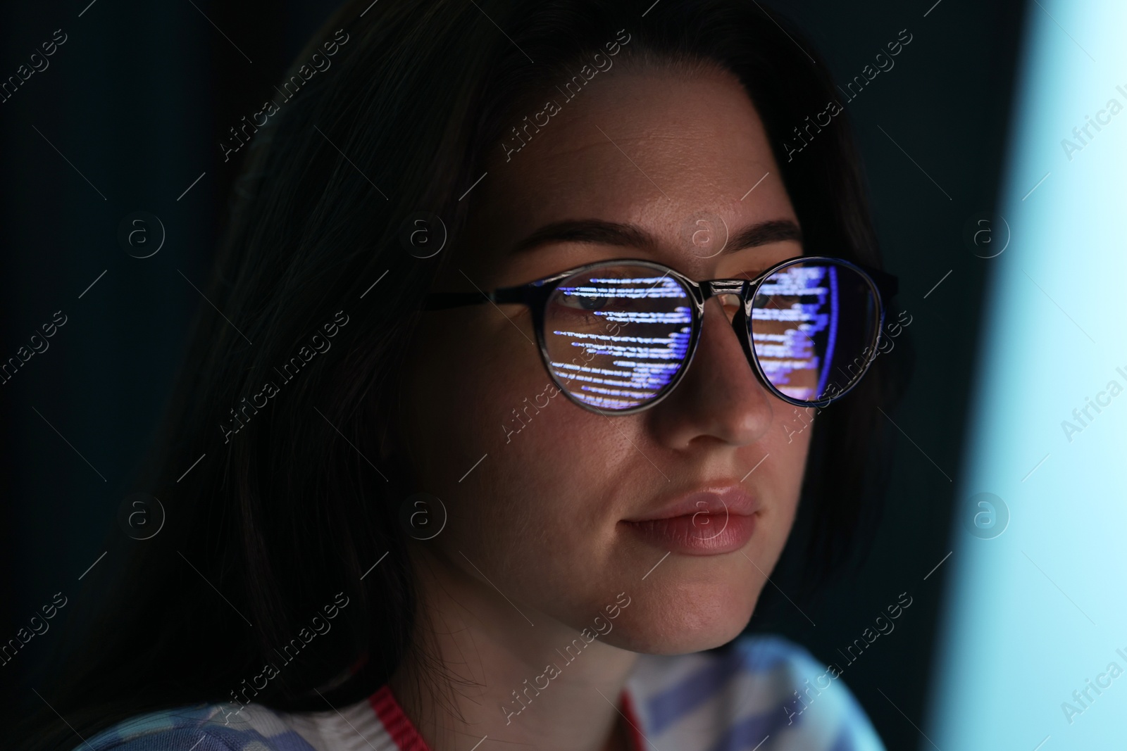 Young woman wearing glasses with reflection on dark background, closeup Photo of Young woman wearing glasses with reflection on dark background, closeup