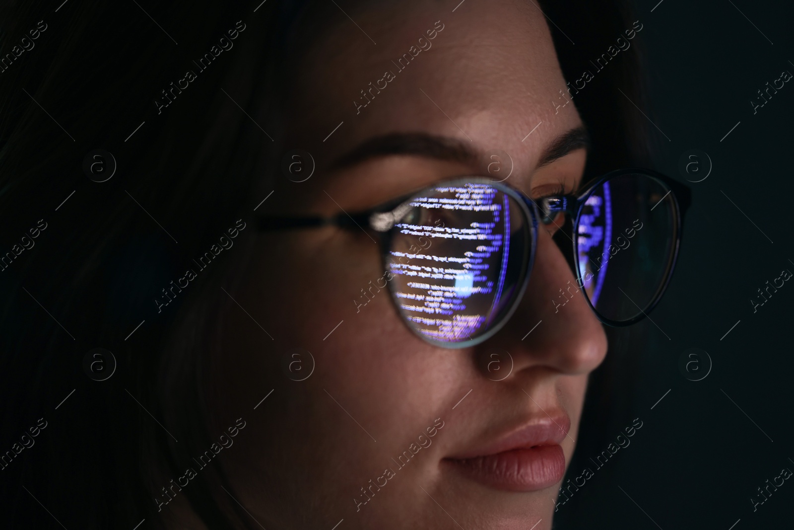 Young woman wearing glasses with reflection on dark background, closeup Photo of Young woman wearing glasses with reflection on dark background, closeup