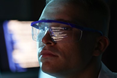 Photo of Young man wearing glasses with reflection on blurred background, closeup