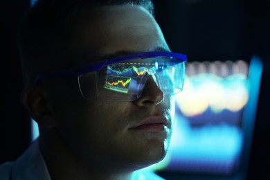 Photo of Young man wearing glasses with reflection on blurred background, closeup