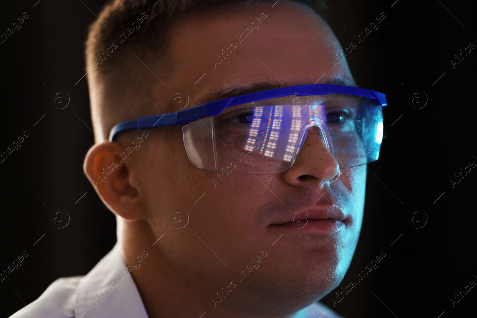 Young man wearing glasses with reflection on dark background, closeup Photo of Young man wearing glasses with reflection on dark background, closeup