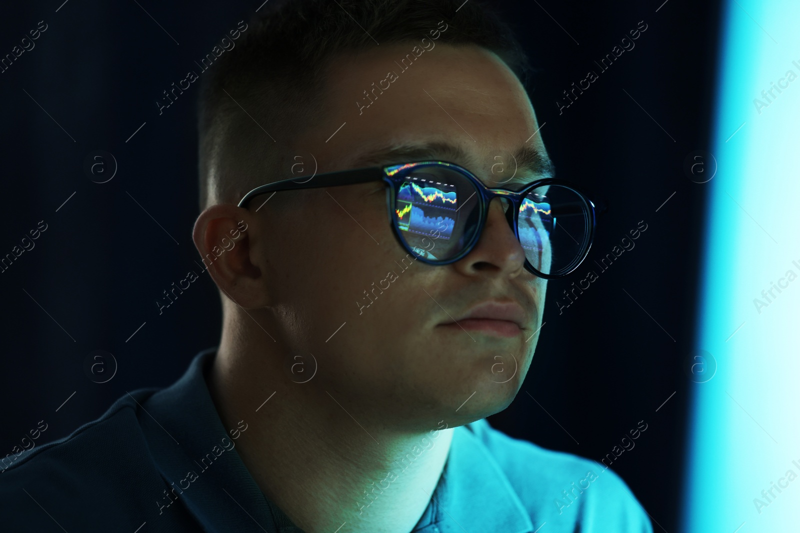 Young man wearing glasses with reflection on dark background, closeup Photo of Young man wearing glasses with reflection on dark background, closeup