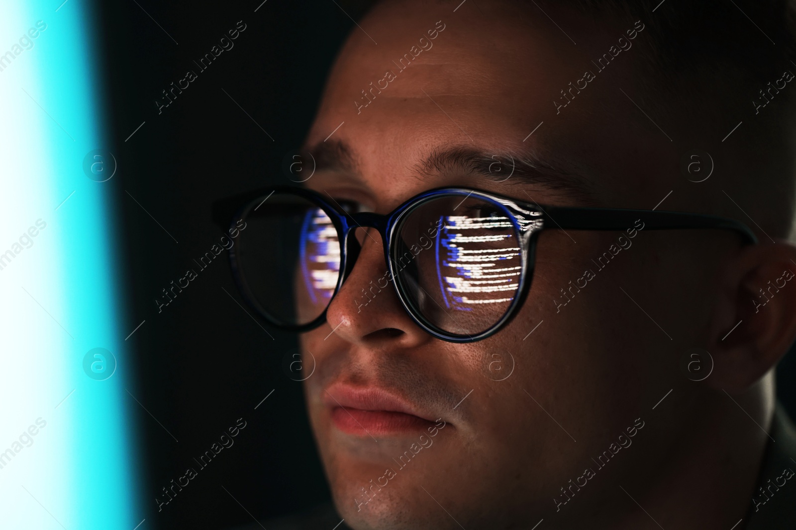 Young man wearing glasses with reflection on dark background, closeup Photo of Young man wearing glasses with reflection on dark background, closeup