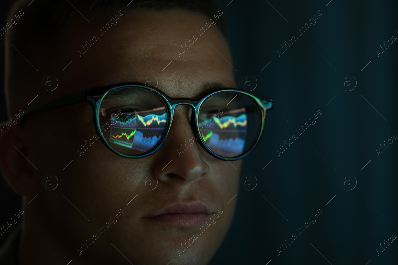 Young man wearing glasses with reflection on dark background, closeup Photo of Young man wearing glasses with reflection on dark background, closeup