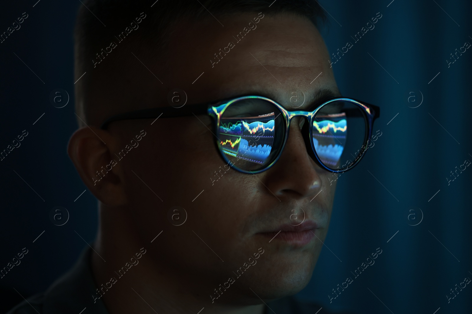 Young man wearing glasses with reflection on dark background, closeup Photo of Young man wearing glasses with reflection on dark background, closeup