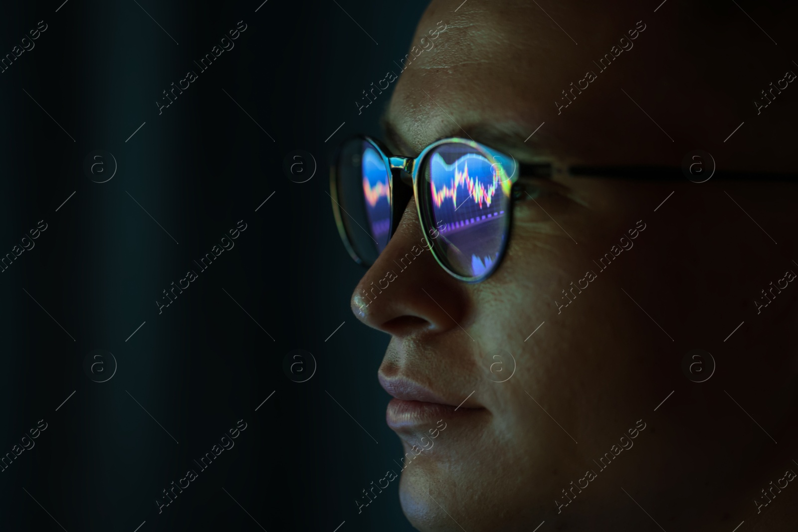 Young man wearing glasses with reflection on dark background, closeup Photo of Young man wearing glasses with reflection on dark background, closeup