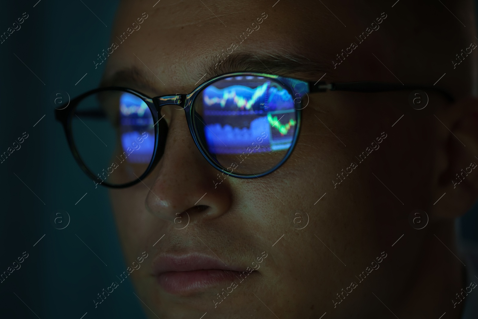 Young man wearing glasses with reflection on dark background, closeup Photo of Young man wearing glasses with reflection on dark background, closeup