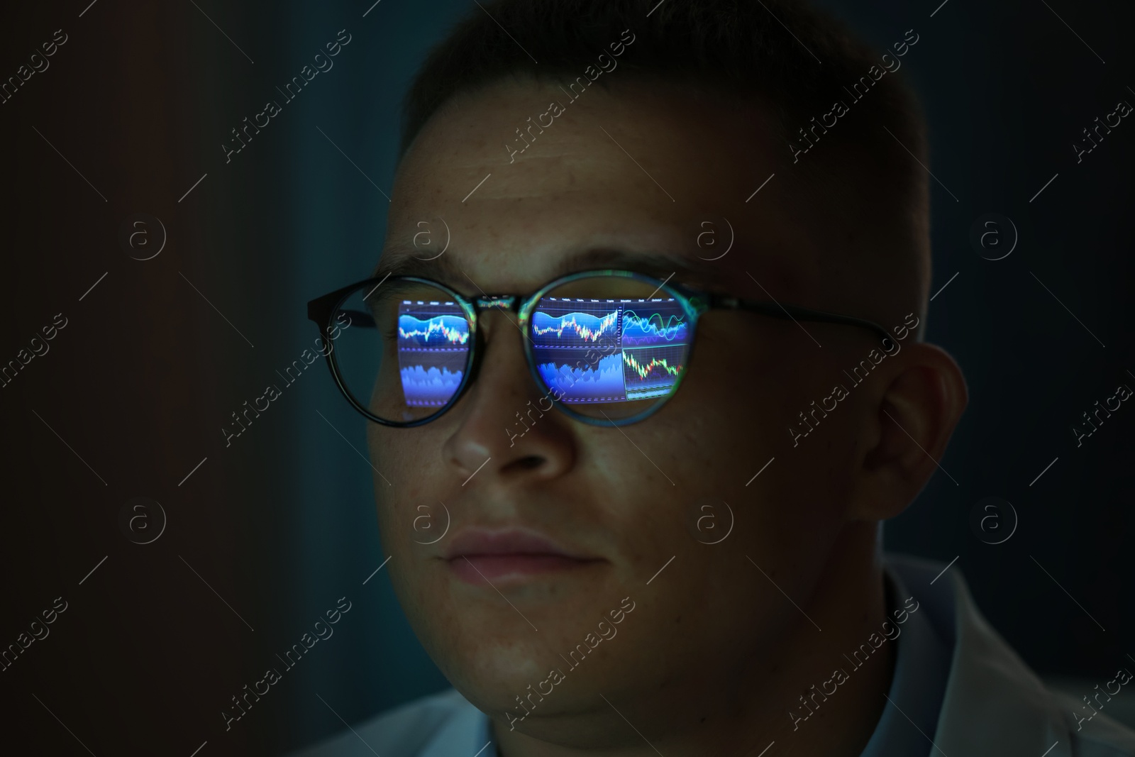 Young man wearing glasses with reflection on dark background, closeup Photo of Young man wearing glasses with reflection on dark background, closeup