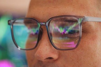 Photo of Young man wearing glasses with reflection on blurred background, closeup