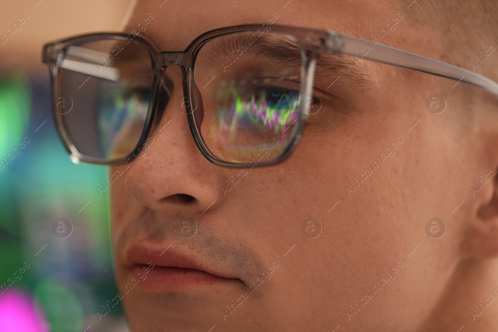Young man wearing glasses with reflection on blurred background, closeup Photo of Young man wearing glasses with reflection on blurred background, closeup