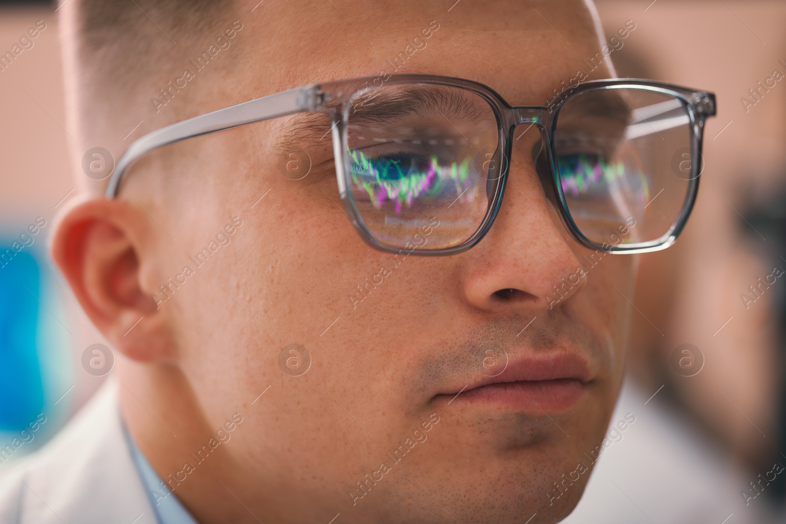 Young man wearing glasses with reflection on blurred background, closeup Photo of Young man wearing glasses with reflection on blurred background, closeup