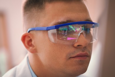 Photo of Young man wearing glasses with reflection on blurred background, closeup