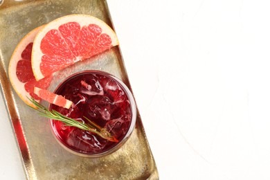 Photo of Tasty cocktail with grapefruit, ice cubes and rosemary on white table, top view. Space for text