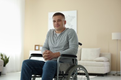 Photo of Young man in modern wheelchair at home