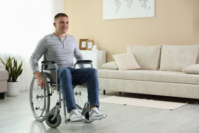 Photo of Young man in wheelchair at home, space for text