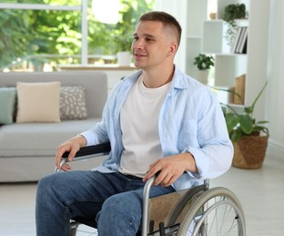 Photo of Young man in modern wheelchair at home