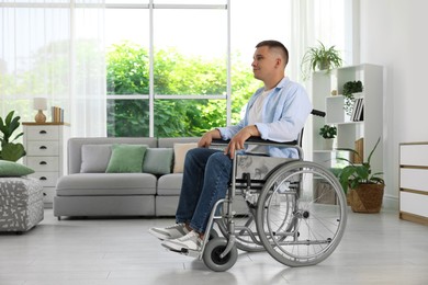 Photo of Young man in modern wheelchair at home