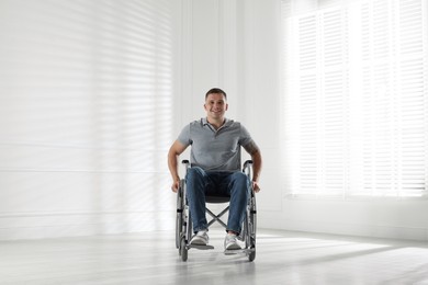 Photo of Young man in modern wheelchair at home