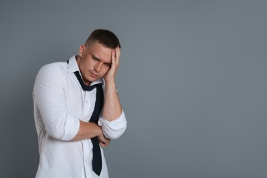 Photo of Man suffering from hangover on grey background, space for text
