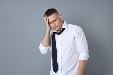 Photo of Man suffering from hangover on grey background