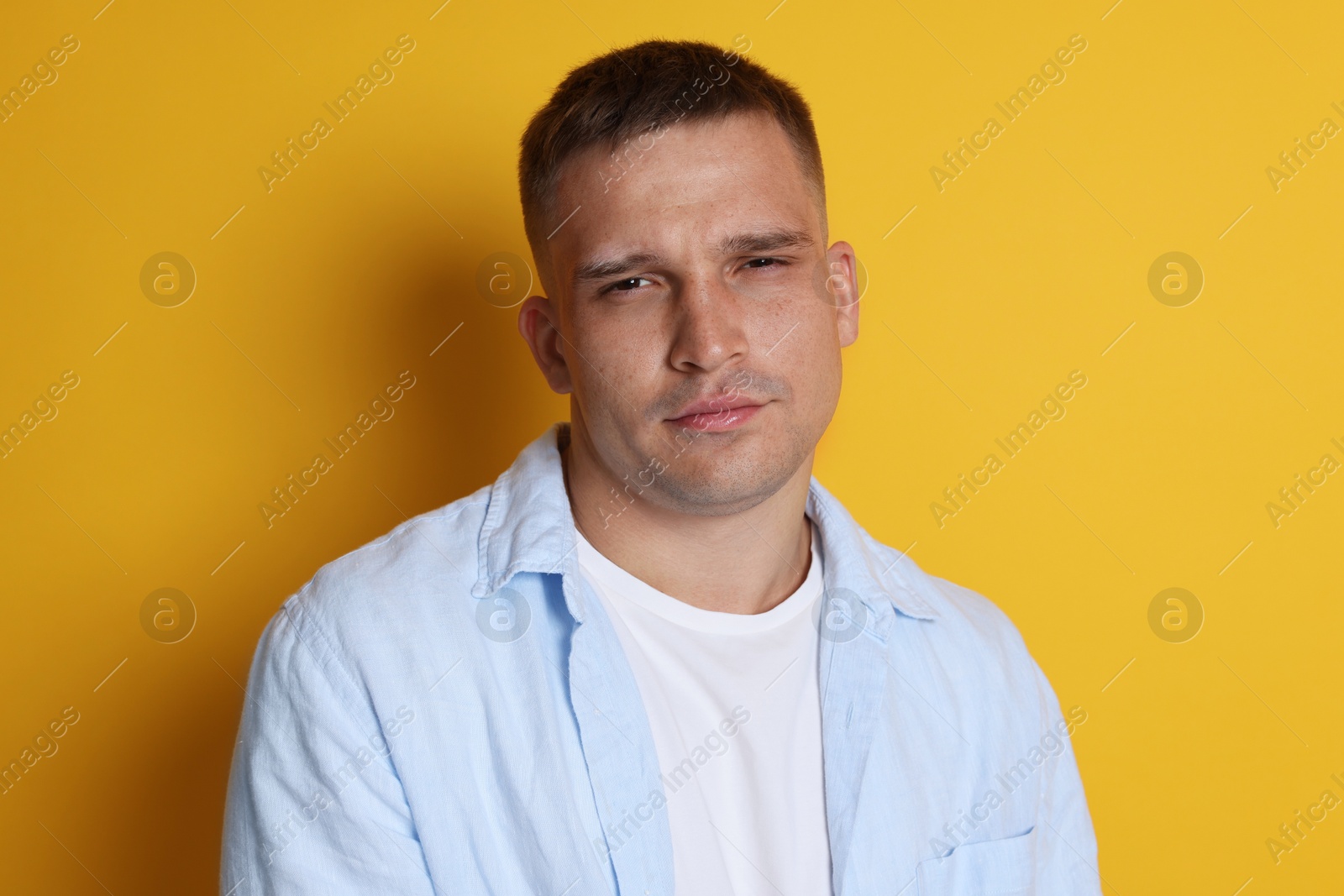 Man suffering from hangover on orange background Photo of Man suffering from hangover on orange background
