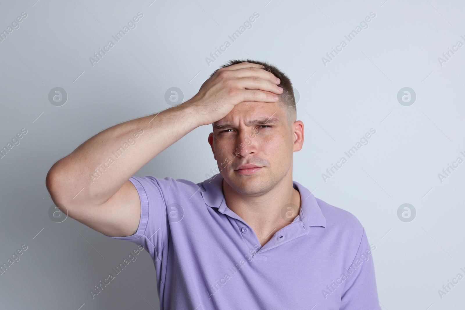 Photo of Man suffering from hangover on light grey background