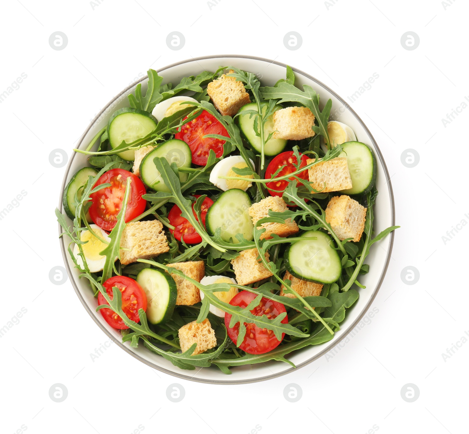 Photo of Tasty salad with croutons, cucumbers, tomatoes and arugula isolated on white, top view