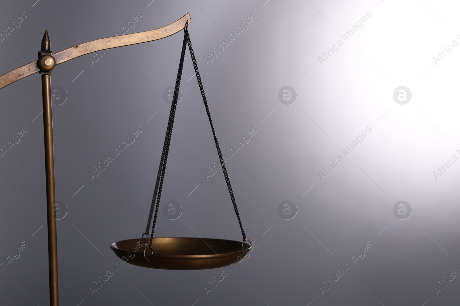 Photo of Scales of justice against grey background, closeup. Space for text