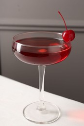 Photo of Tasty cherry cocktail on white table, closeup