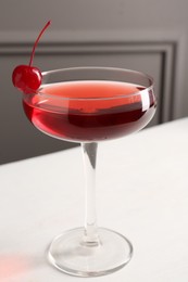 Photo of Tasty cherry cocktail on white table, closeup