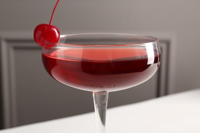 Photo of Tasty cherry cocktail on white table, closeup