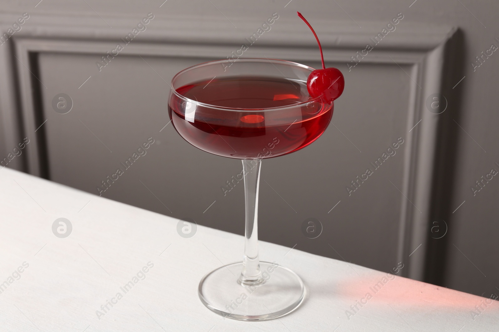 Photo of Tasty cherry cocktail on white table, closeup