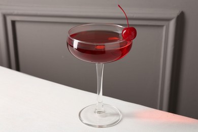 Photo of Tasty cherry cocktail on white table, closeup