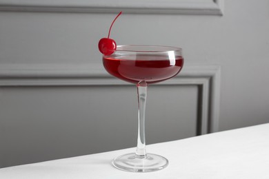 Photo of Tasty cherry cocktail on white table, closeup