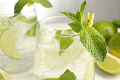 Photo of Tasty cocktail with lime and ice cubes on table, closeup